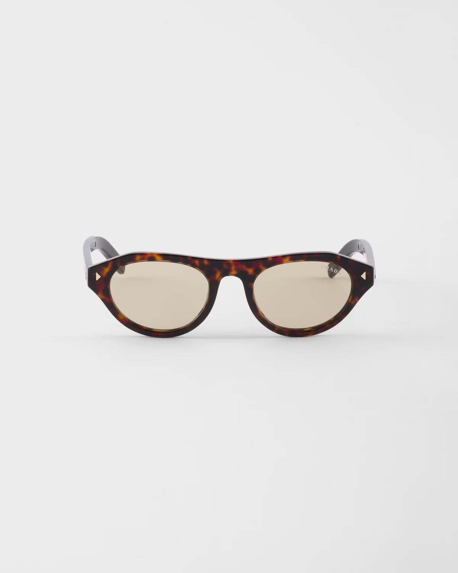 Sunglasses with tortoiseshell frame and beige lenses on a white background